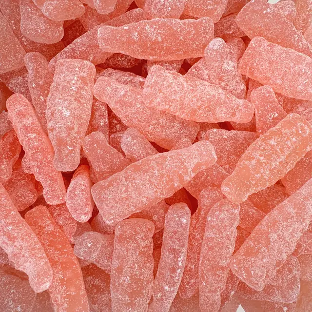 Pale pink sugar-coated candies shaped like bottles