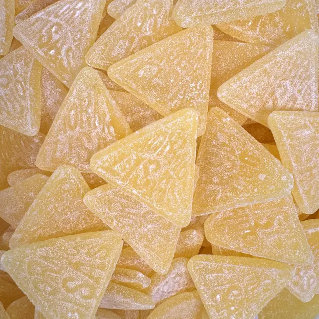 A pile of pale yellow sugar-coated triangle candies
