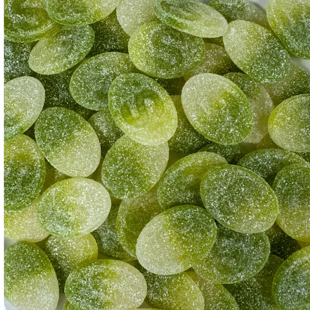 Green sugar-coated apple candies stamped with an S