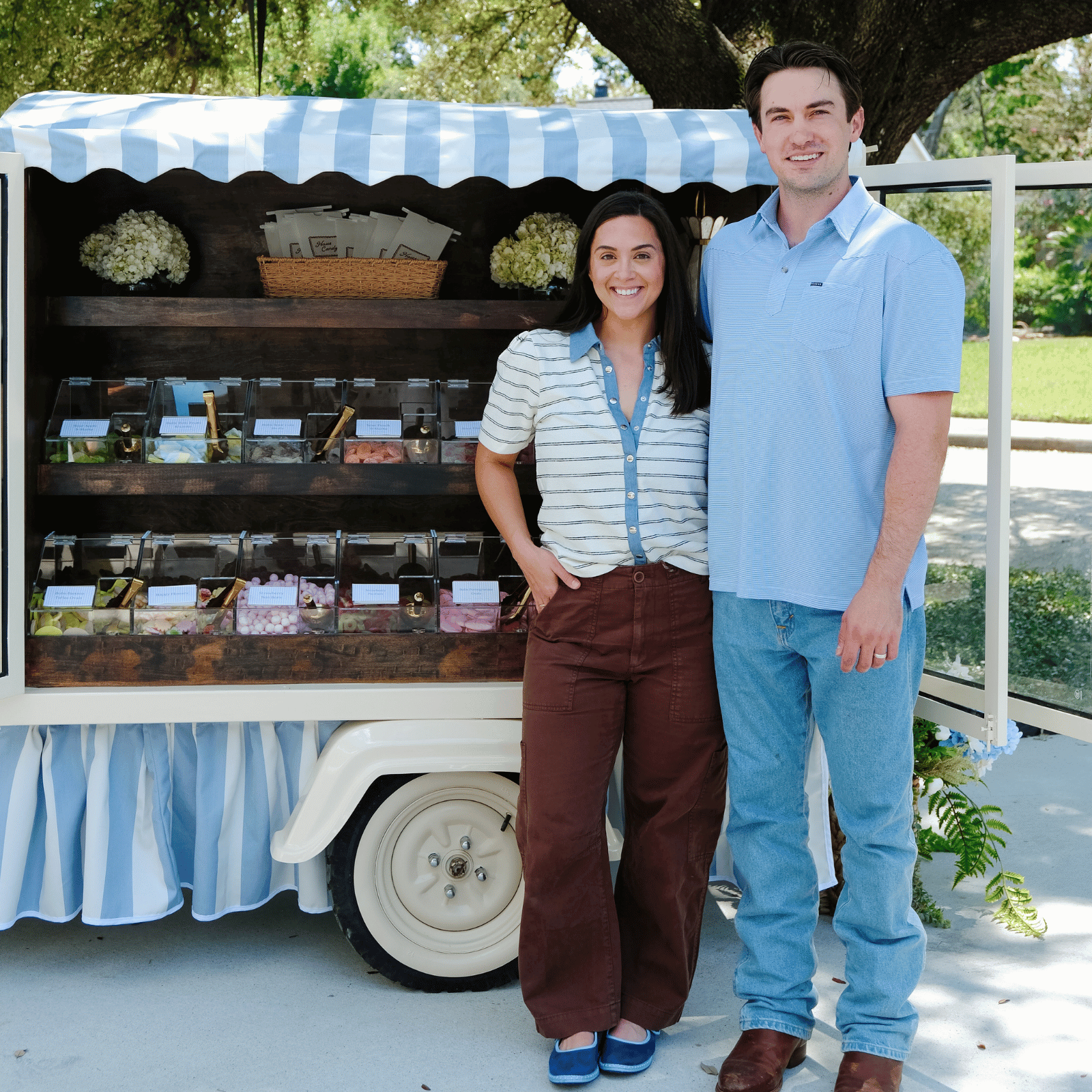 Chelcie and Adam Aldred standing beside the stocked Haus Candy Cart