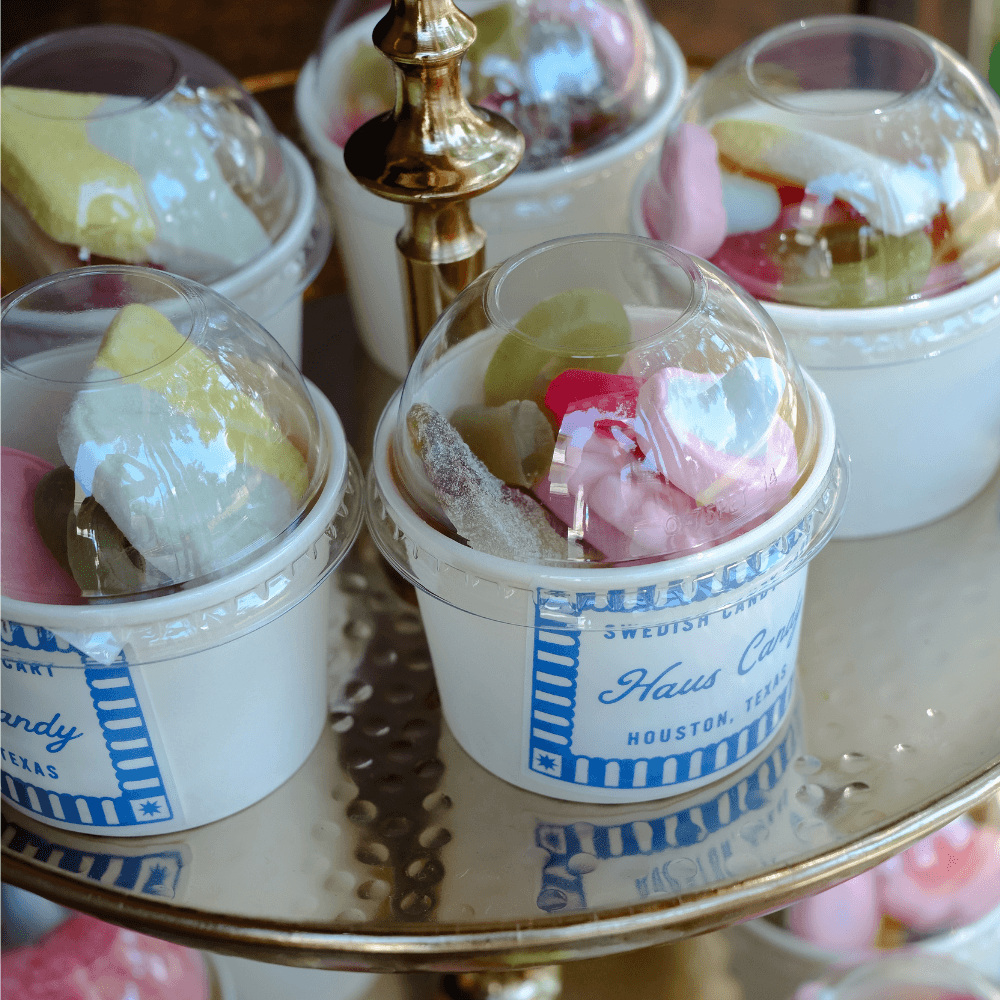 Individually packed Haus Candy cups displayed on a gold tiered tray