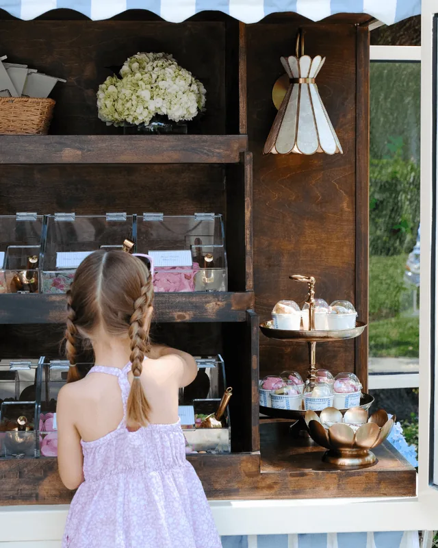A child in a lavender dress choosing candy from the cart display